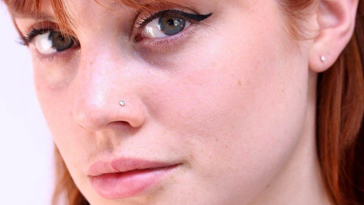 Woman wearing a small sparkling nose stud and a matching stud earring